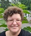 Photo of Clary Gasper, smiling woman, short curly brown hair